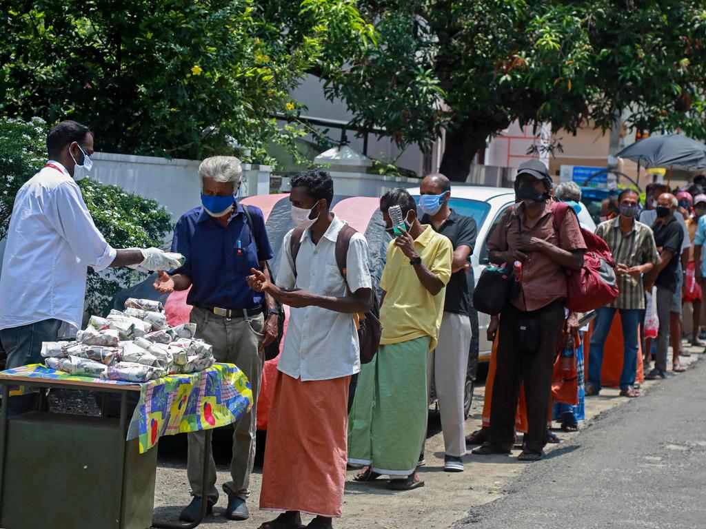 A member of a non-governmental organisation distributes free food packets to the needy amid the coronavirus pandemic in Kochi. Picture: Arunchandra Bose