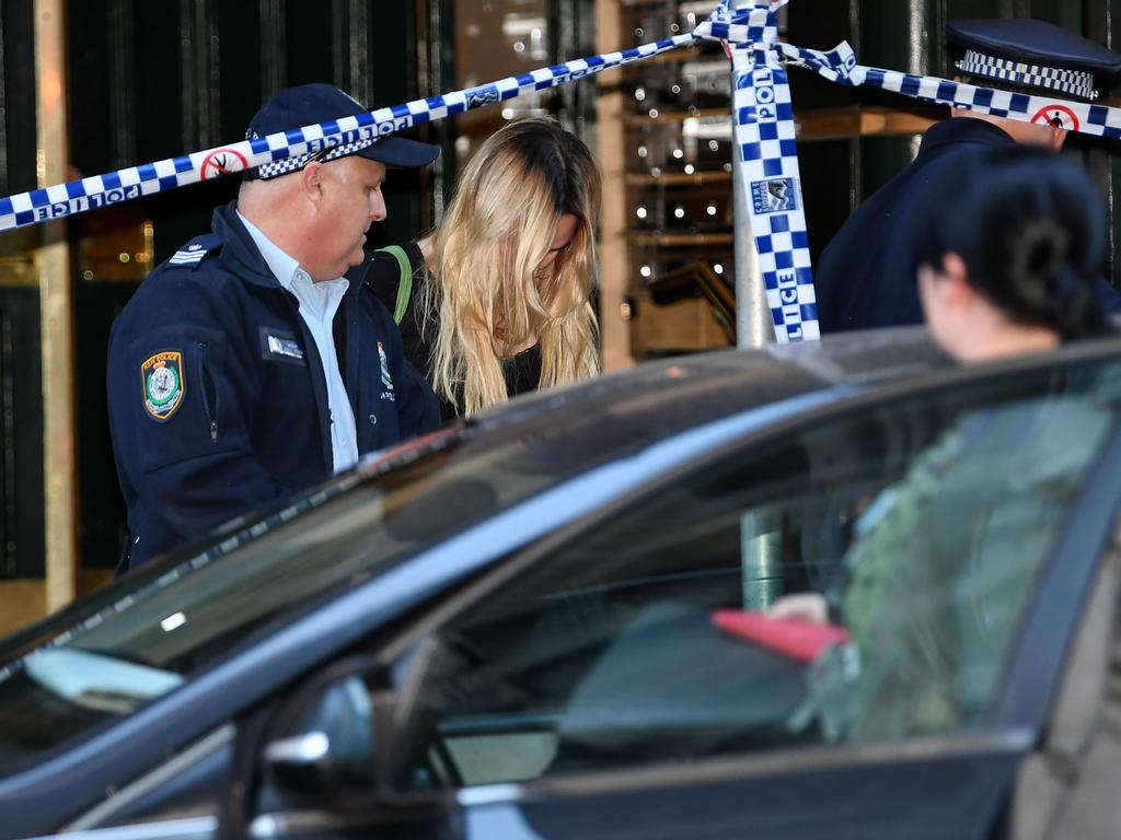 Police escort away a woman from a building near the scene of a knife rampage in Sydney on August 13, 2019. Picture: Saeed KHAN / AFP.