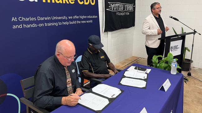 The Yothu Yindi Foundation and Charles Darwin University representatives co-sign a memorandum of understanding for the new school. Picture: Adnan Reza