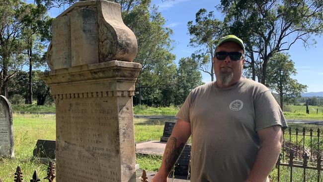 Scott Stewart with one of the grave stones crudely pieced back together. Picture: Janine Watson.