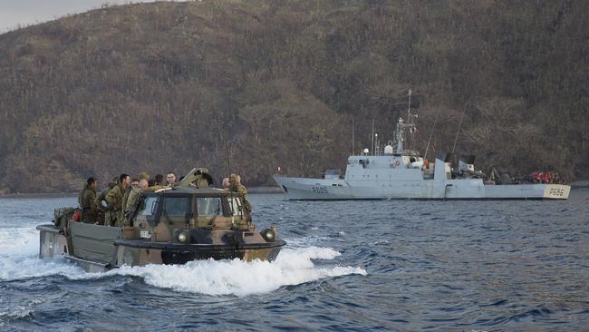 Australian Army soldiers in an Australian LARC-V amphibious vehicle pass a French naval vessel during Operation Pacific Assist 2015 mission.