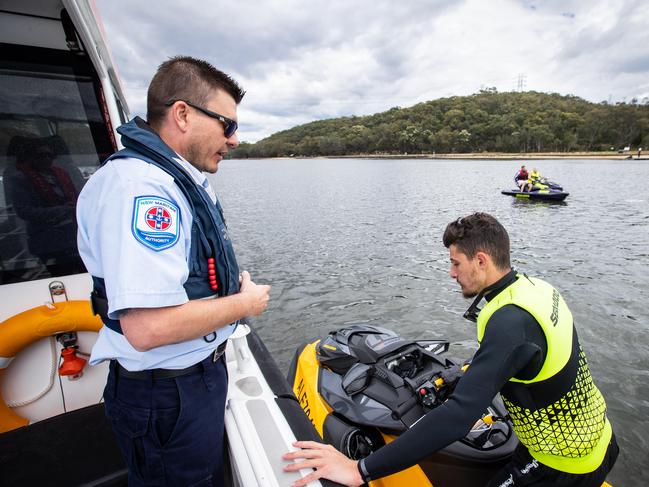 Senior Maritime Safety Officer Shane Davey checks a jetskier’s licence on the Georges River in Revesby. Pictures: Julian Andrews.