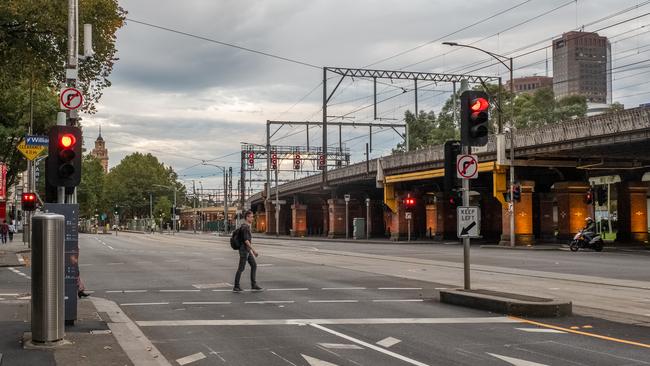 A lone man crosses the usually busy Flinders St. Picture: Asanka Ratnayake/Getty Images