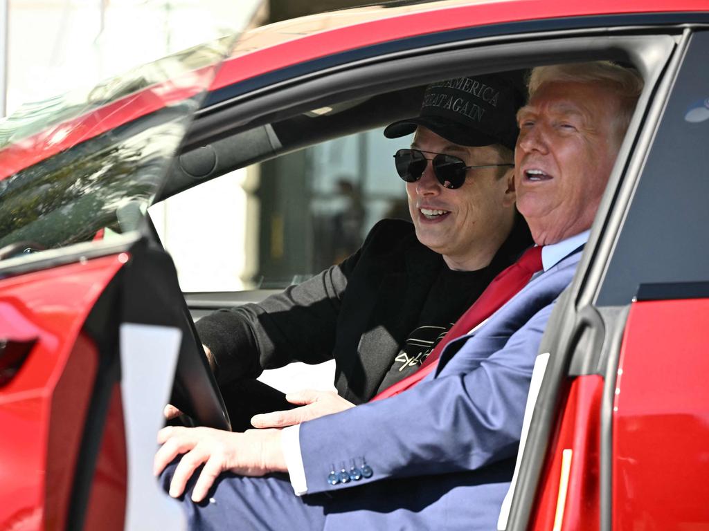 (FILES) US President Donald Trump and Tesla CEO Elon Musk speak to the press as they sit in a Tesla vehicle on the South Portico of the White House on March 11, 2025 in Washington, DC. Elon Musk will significantly scale back his Trump administration work in May to focus on Tesla, the billionaire announced April 22 as the electric vehicle maker reported a 71 percent drop in first-quarter profits. 