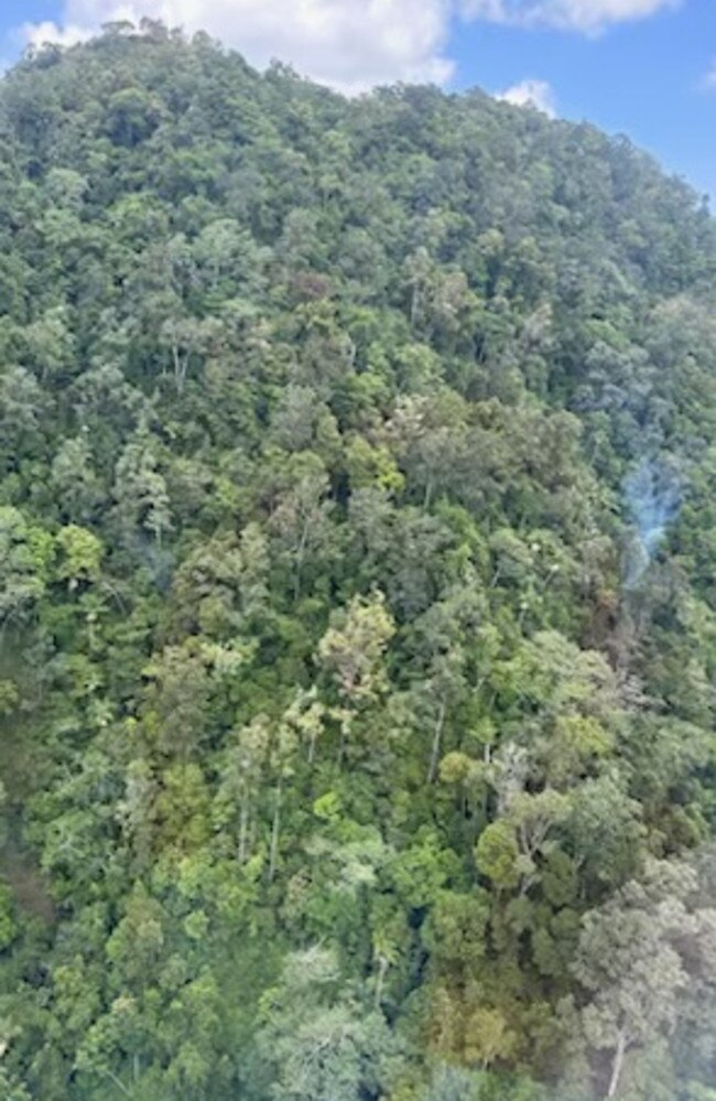 Smoke rising from the thick tree coverage of a mountain range north of Okuloo and Netherdale where it is understood a plane crashed on Saturday, October 28, 2023. Picture: RACQ CQ Rescue