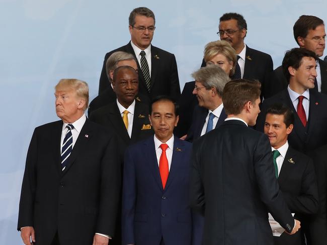 On the outskirts: G20 tradition dictates seniority is a key indicator of where leaders stand. Donald Trump was on the fringe before French President Macron took his place in a picture that seems to underscore his differences on policies such as trade and climate. Picture: Sean Gallup/Getty Images