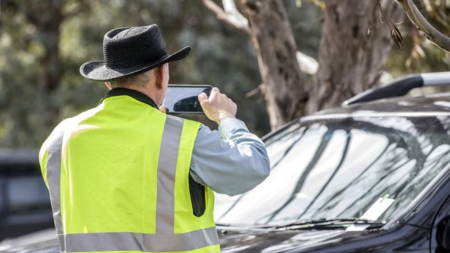 A parking inspector writes up a ticket at Melbourne Zoo.