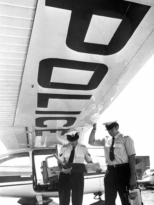 1976: Officers do a preflight check below the wing of a Cesna 185 as the Victorian police sky patrol prepares for take off at Moorabbin airport. File picture