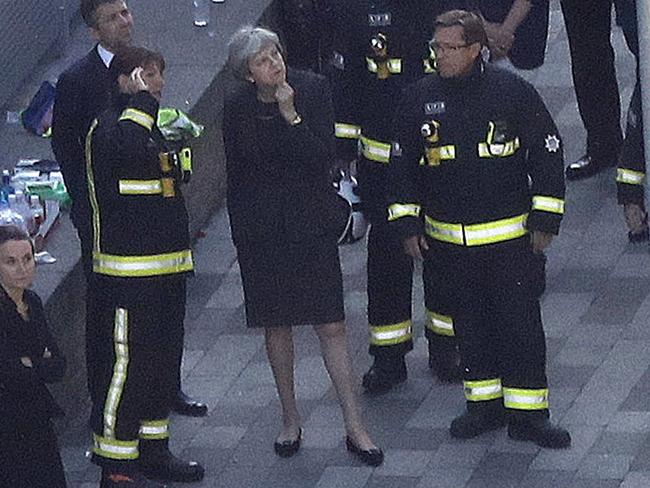 British Prime Minister Theresa May speaks to firefighters after arriving at Grenfell Tower in London. Picture: AP Photo/Frank Augstein