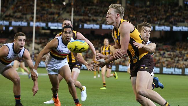 Hawthorn's James Sicily fires off a handball under pressure from the Crows. Picture: Michael Klein