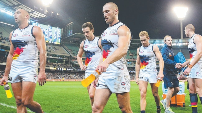 MELBOURNE, AUSTRALIA - MAY 25: James Podsiadly (L) and Scott Thompson of the Crows walk offloads the ball in a tackle after losing during the round 10 AFL match between the Carlton Blues and the Adelaide Crows at Melbourne Cricket Ground on May 25, 2014 in Melbourne, Australia. (Photo by Michael Dodge/Getty Images)