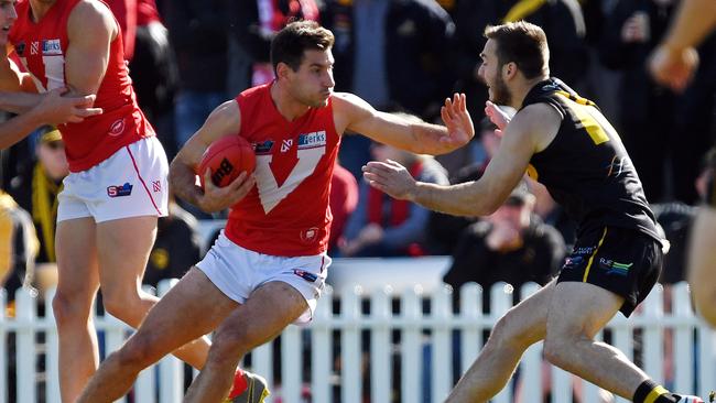 North’s Aidan Tropiano fends off Glenelg's Cory Gregson. Picture: Tom Huntley