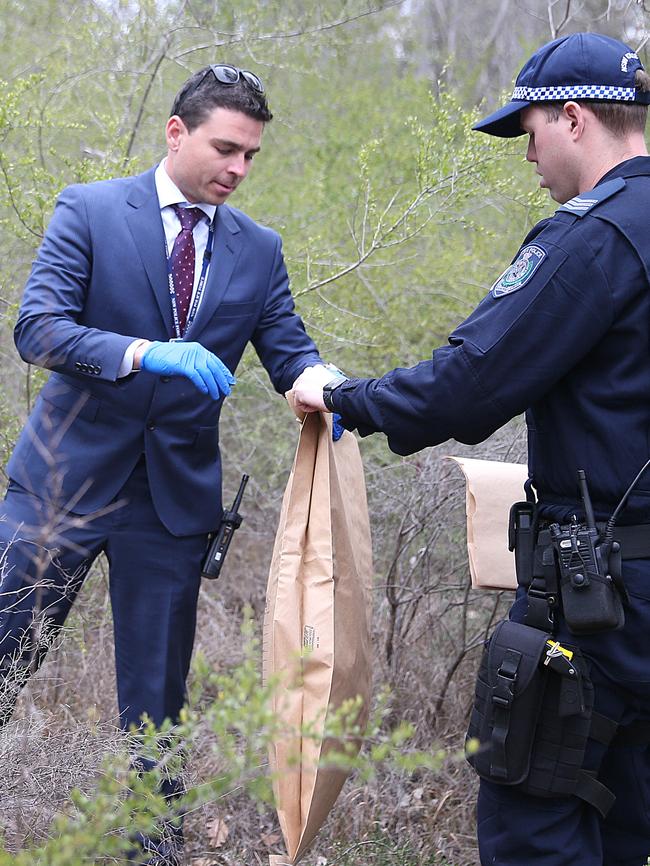 Grisly... Police search bushland for evidence.