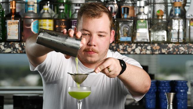 Bartender Patrick Hill double strains to separate pulp and ice from a Jade Goddess cocktail. The drink includes rum, Midori, kiwi fruit and lime juice. Picture: Shae Beplate.