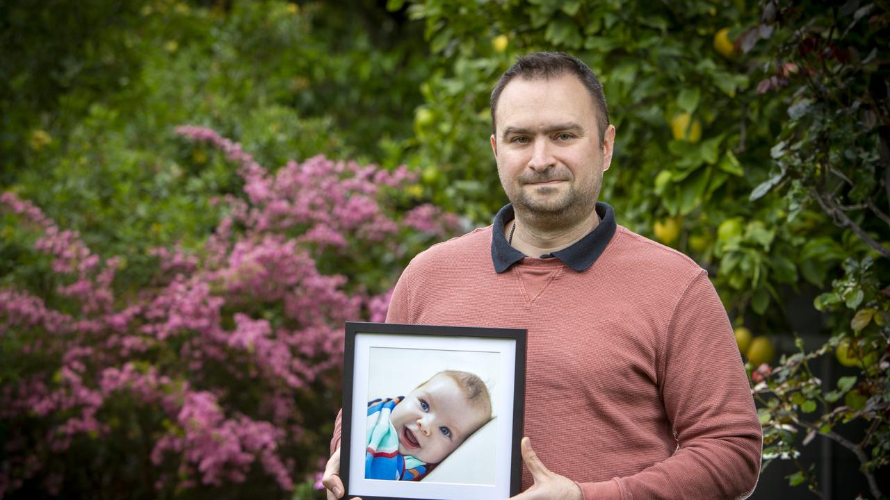 Frank holding an image of his daughter Penny, who died at 4 months old. Picture Emma Brasier