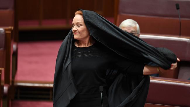 One Nation Senator Pauline Hanson takes off a burqa during Senate Question Time at Parliament House in Canberra, Thursday, August 17, 2017. (AAP Image/Lukas Coch) NO ARCHIVING