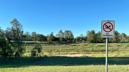 "No swimming" sign at Lake Apex, Gatton highlighting how the area would usually be full of water. Photo: Hugh Suffell.