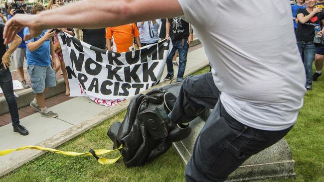 A protester kicks the toppled statue of a Confederate soldier after it was pulled down in North Carolina this week. (Pic: Casey Toth/AP)