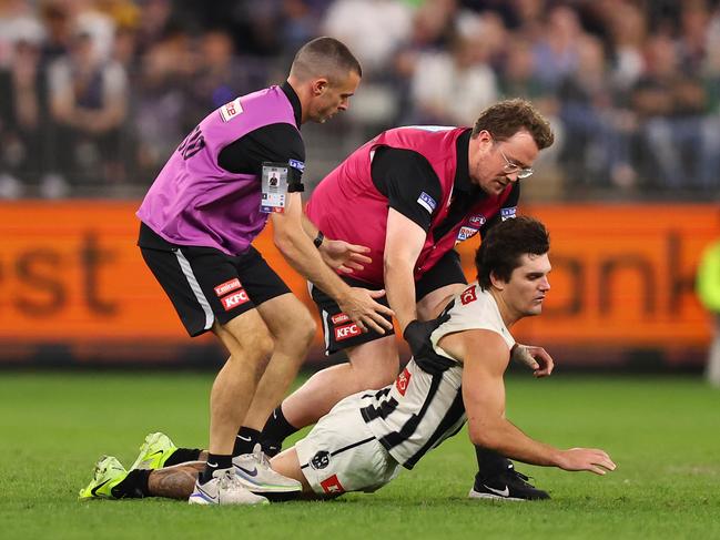 Lachie Schultz collapses in the hands of medical staff while walking from the field. Picture: Paul Kane/Getty Images