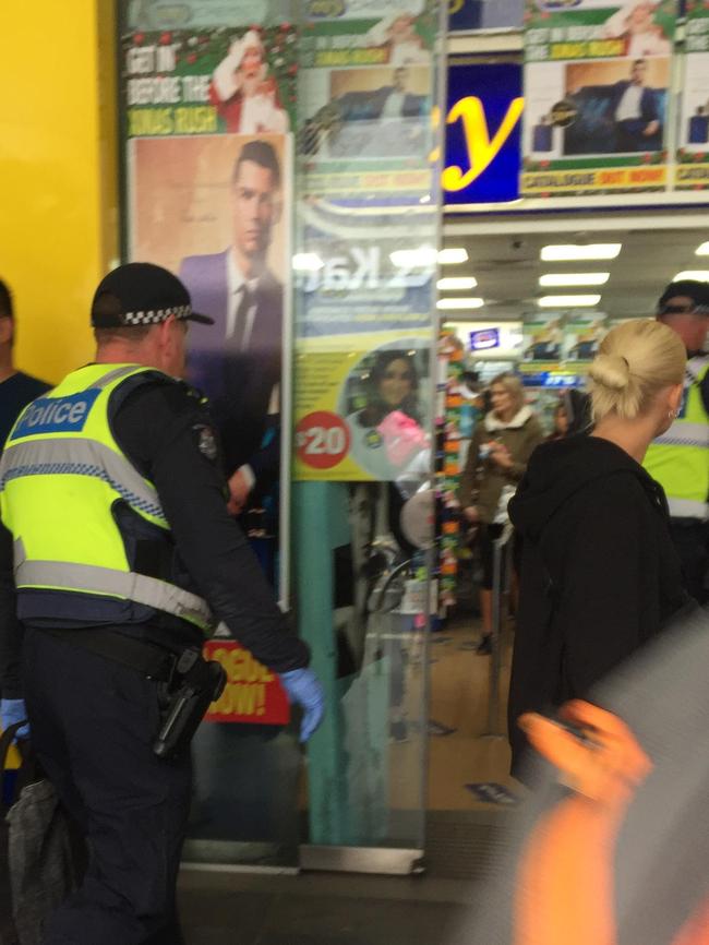 Police outside My Chemist on Elizabeth St after a man was seen on the roof of the shop. Picture: Andrea Hamblin.