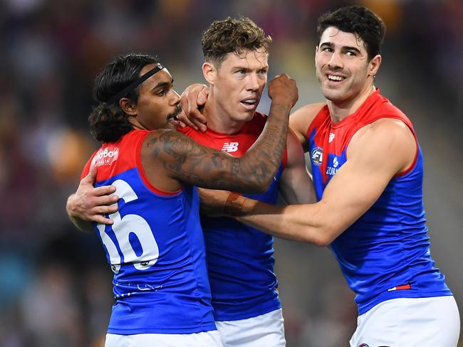 BRISBANE, AUSTRALIA - AUGUST 19: Christian Petracca of the Demons celebrates with Kysaiah Pickett and Jake Melksham after kicking a goal during the round 23 AFL match between the Brisbane Lions and the Melbourne Demons at The Gabba on August 19, 2022 in Brisbane, Australia. (Photo by Albert Perez/AFL Photos via Getty Images)