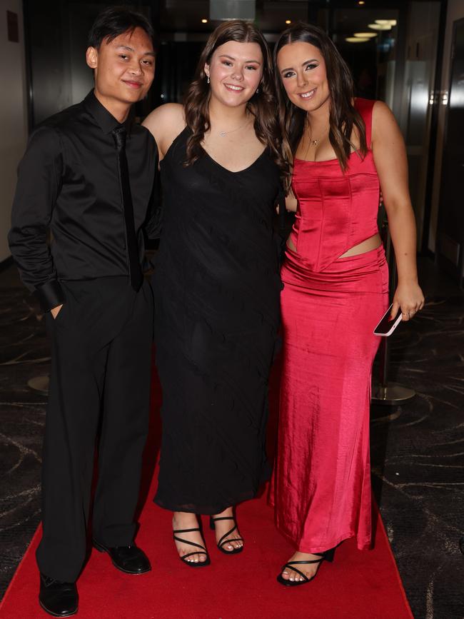 MELBOURNE, AUSTRALIA – JUNE 14 2024 Aaron Abuan, Eliza Thornby, Steph Nowell attend the Lowanna College Senior Formal 2024 at the Moe Racing Club Picture: Brendan Beckett