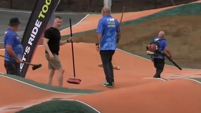 Volunteers use brooms and an air blower to remove water from the Sam Willoughby International BMX Facility Picture: AusCycling.