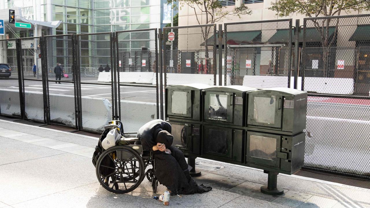 A person slumped over in a wheelchair next to security fencing for the Asia-Pacific Economic Cooperation (APEC) summit in San Francisco, on November 13, 2023. Picture: Jason Henry / AFP