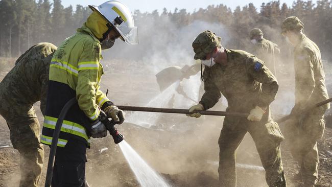 Australian soldiers from the 9th Regiment, Royal Australian Artillery, work with the Country Fire Service to put out hotspots and prevent reignition of bushfires on Kangaroo Island. Picture: Supplied.