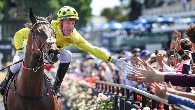 Melbourne Cup-winning jockey Mark Zahra high fives members of the crowd after riding Without a Fight to victory on Tuesday. Picture: David Caird