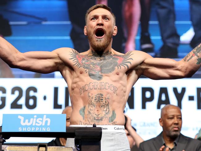 UFC lightweight champion Conor McGregor poses on the scale.