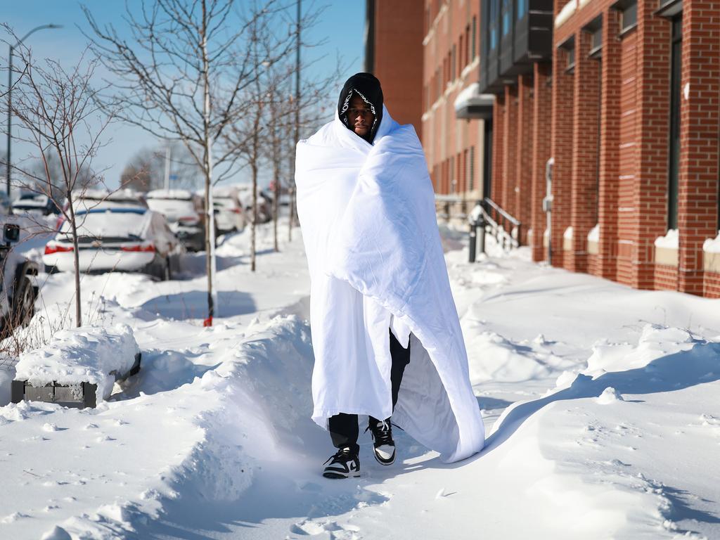 Diamani Glo braves the chilly -12°C weather in Des Moines, Iowa, wrapped in a blanket amidst snowfall. The icy blast hits as locals gear up for the Republican caucuses. Picture: Joe Raedle/Getty Images