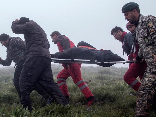 TOPSHOT - Rrescuers recover bodies at the crash site of a helicopter transporting Iran's President, his Foreign Minster, and others in a fog-covered mountainous area of Varzaghan in northwestern Iran on May 20, 2024. Iranian President Ebrahim Raisi was declared dead on May 20, 2024, after rescue teams found his crashed helicopter in a fog-shrouded western mountain region, sparking mourning in the Islamic republic. (Photo by Azin HAGHIGHI / MOJ News Agency / AFP)