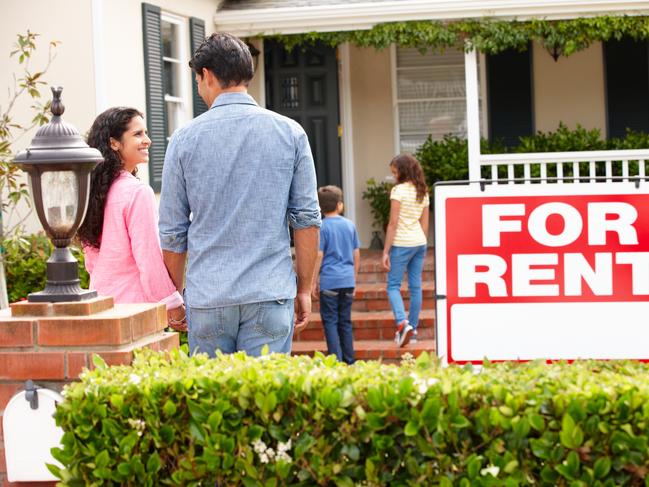 Hispanic family outside home for rent holding hands looking at each other happy