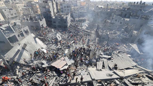 People search for survivors and the bodies of victims through the rubble of buildings destroyed during Israeli bombardment, in Khan Yunis in the southern Gaza Strip on October 26.