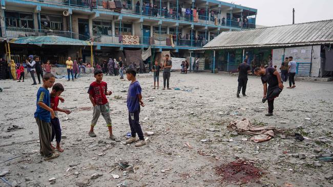 Palestinian boys stand near blood stain at a UN-school housing displaced people that was hit during Israeli bombardment in Nuseirat, in the central Gaza Strip. Picture: AFP