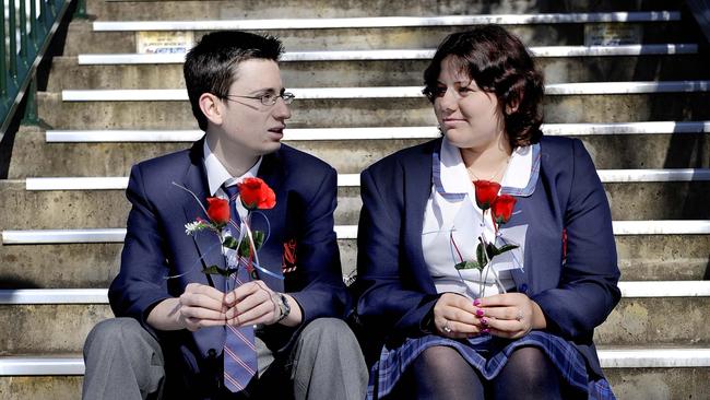 End of an era: A look back at McCarthy Catholic College: Rebecca Smith and Cameron Smith from McCarthy College wait for the next commuter train to pull into Emu Plains Station to deliver their roses as a thank you to their community for their muck-up day activity.