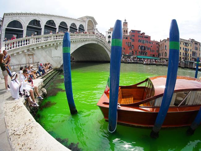 TOPSHOT - A photo taken and made available on May 28, 2023 by Italian news agency Ansa, shows fluorescent green waters below the Rialto Bridge in Venice's Grand Canal. The prefect called an urgent meeting on May 28 with the police to investigate the origin of the liquid, as gondoliers were getting lost in conjectures about the color's origin. (Photo by STRINGER / ANSA / AFP) / Italy OUT