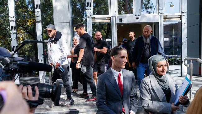 More than a dozen supporters (pictured in the background) for Adam Abdallah after he was denied bail for allegedly assaulting a referee. Picture: David Swift/NCA NewsWire