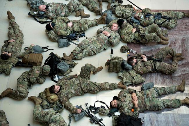 Members of the National Guard rest in the Capitol Visitors Center on Capitol Hill in Washington, DC, January 13, 2021, ahead of an expected House vote impeaching US President Donald Trump. - The Democrat-controlled US House of Representatives on Wednesday opened debate on a historic second impeachment of President Donald Trump over his supporters' attack of the Capitol that left five dead.Lawmakers in the lower chamber are expected to vote for impeachment around 3:00 pm (2000 GMT) -- marking the formal opening of proceedings against Trump. (Photo by Brendan Smialowski / AFP)