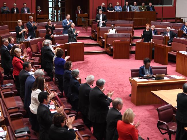 Senators from both sides join in applauding Attorney-General George Brandis for criticising One Nation Senator Pauline Hanson for wearing a burqa. Picture: AAP