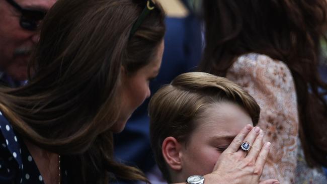 Don’t look … Britain's Catherine, Duchess of Cambridge (left) covers the eyes of her son, Prince George, during men's singles final. Picture: AFP