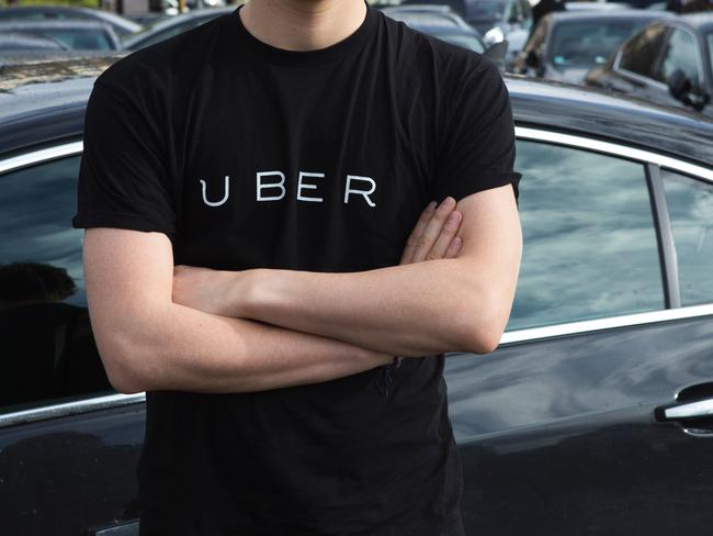 (FILES) This file photo taken on February 09, 2016 shows a man wearing a shirt displaying the logo of smartphone ride service Uber during a protest at the Place de la Nation in Paris. Uber announced on December 1, 2016 that it would increase its rates from 10 to 15 percent in France. / AFP PHOTO / Geoffroy Van der Hasselt