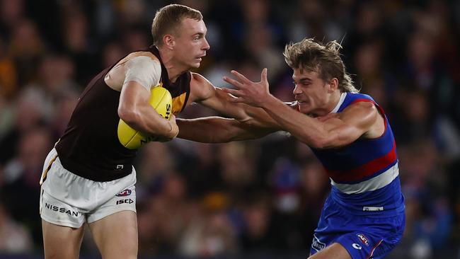 MELBOURNE. 29/04/2023. AFL. Round 7.     Western Bulldogs vs Hawthorn at Marvel Stadium . James Worpel of the Hawks   fends off Bulldog Bailey Smith   . Pic: Michael Klein