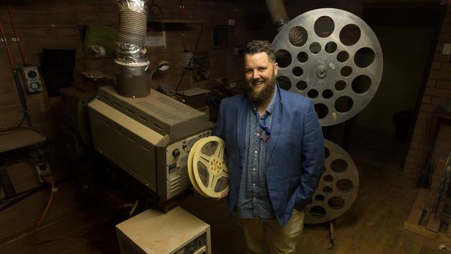 Matthew Key, the volunteer projectionist at the Coober Pedy drive-in theatre in outback South Australia, in the old projection booth with vintage equipment made redundant by digital technology. Picture: Bernard Humphreys