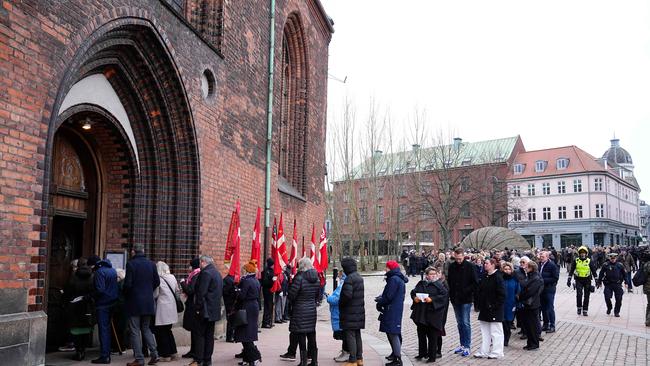 People queue before attending the church service. Picture: AFP