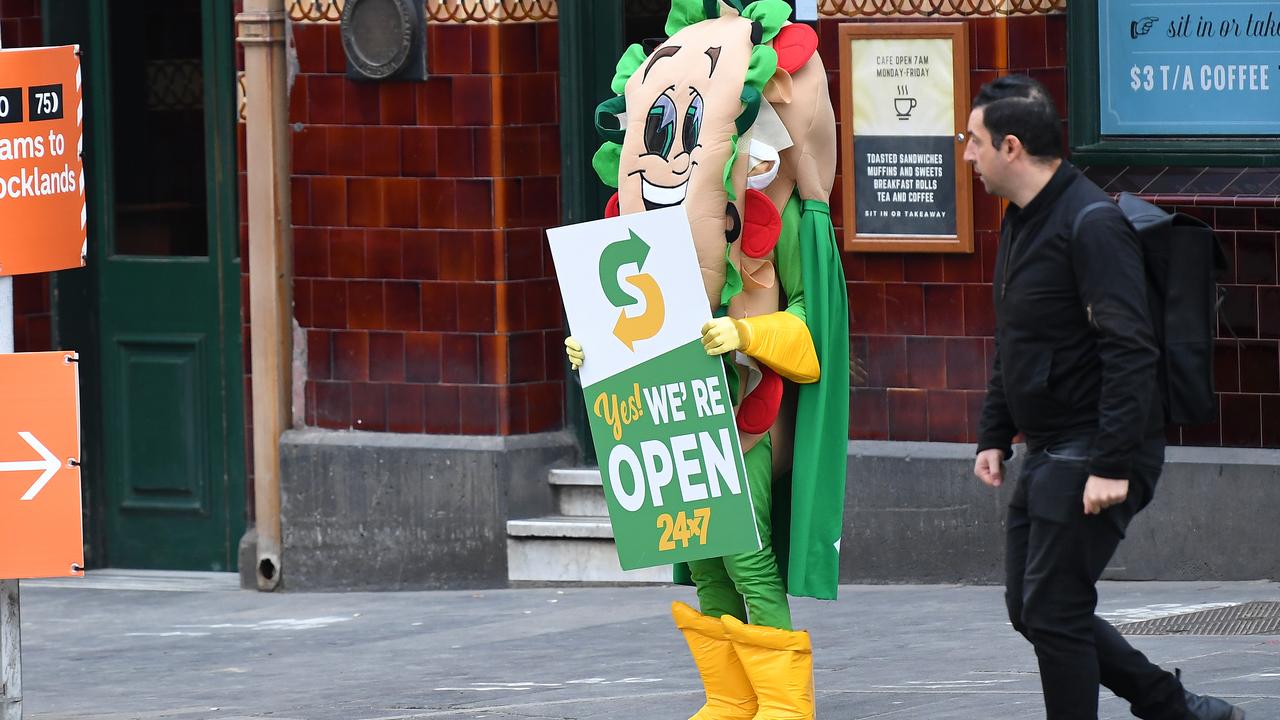 A Subway employee dressed in a costume holds a sign advertising stores are still open is seen in Melbourne, Picture: AAP Image/James Ross