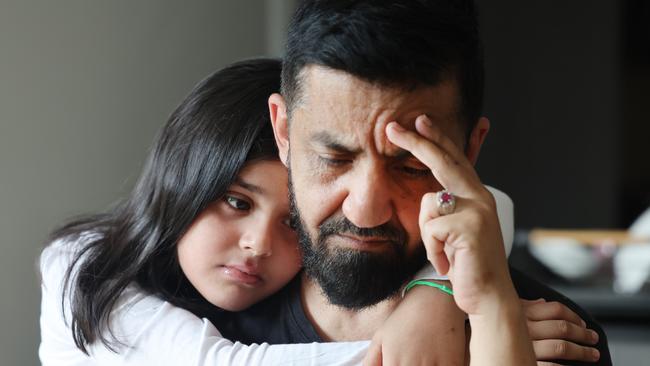 Nine-year-old Zahra Popal gives her father, Ahmad Popal, a hug at their home in Hope Island on the Gold Coast. Picture: Glenn Hampson.