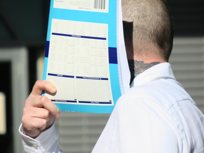 Moujalli covers his face as he arrives at Gosford District Court for an earlier appearance. Picture: NewsLocal