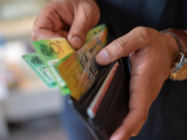 a male taking money out of a wallet, Australian cash generic spending